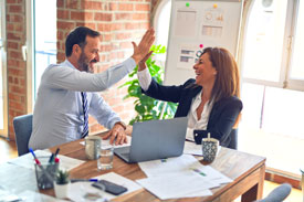 professionals at desk high fiving